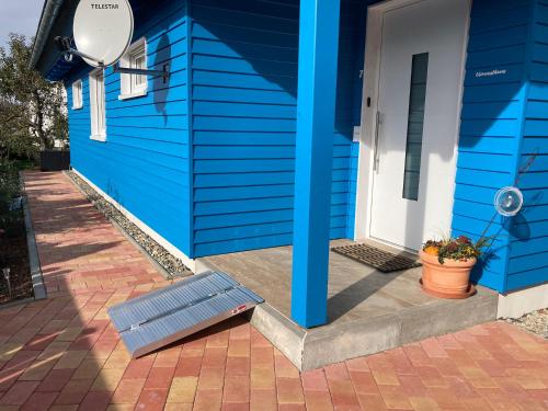a blue house with a bench next to a door at Blaues Ferienhaus Wernigerode in Wernigerode