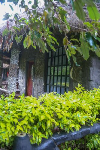 a building with a red door and some green plants at Dovenest Lodge in Naivasha