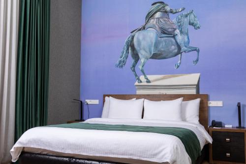 a bed with a statue of a man riding a horse at Theory Hotel in Tbilisi City