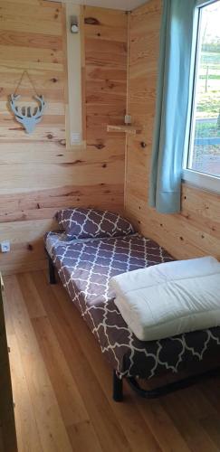 a bedroom with a bed in a log cabin at les chalets de l'essentiel in Lacaze