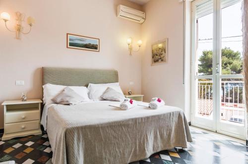 a bedroom with a bed with two stuffed animals on it at Calliope's Apartments - Stella del Mare in Siracusa