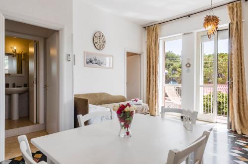 a white dining room with a white table and chairs at Calliope's Apartments - Stella del Mare in Siracusa