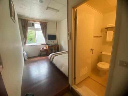 1 dormitorio con cama, aseo y ventana en Lu-Lin B&B, en Wufeng