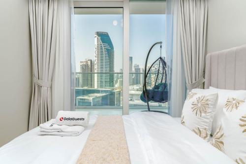 a bedroom with a bed with a view of a city at Delightful 2BR apartment at Reva Residences in Dubai