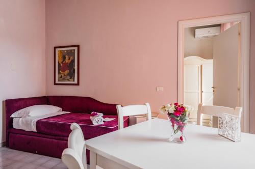 a living room with a bed and a table and chairs at Calliope's Apartments - Stella del Mare in Siracusa