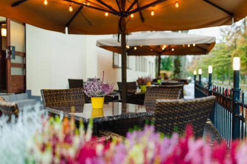 a patio with tables and chairs with umbrellas and flowers at Hotel Legend in Pärnu