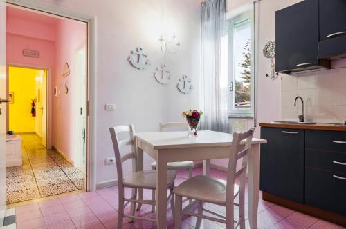 a kitchen with a table and chairs in a kitchen at Calliope's Apartments - Stella del Mare in Siracusa