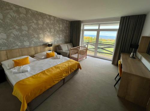 Cette chambre comprend un grand lit et une fenêtre. dans l'établissement Rodinný Hotel Hubert High Tatras, à Vysoké Tatry