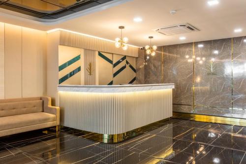 a lobby with a bar with a couch and a chair at City Park Hotel Bangkok Pratunam by PCL in Bangkok