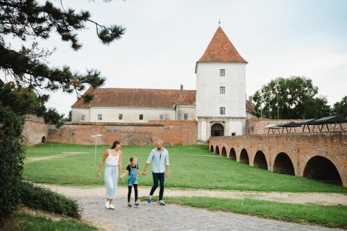 a family walking down a path in front of a castle at Cherry Apartmanház in Sárvár