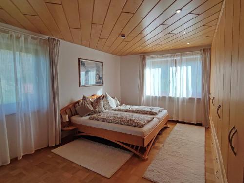 - une chambre avec un lit et une grande fenêtre dans l'établissement Ferienwohnung Haindorfer Berg, à Aschau im Chiemgau