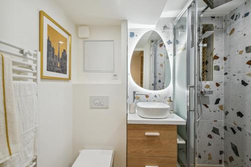 ein Bad mit einem Waschbecken und einem Spiegel in der Unterkunft Hyper centre Écusson - Magnifique T1 au calme in Montpellier