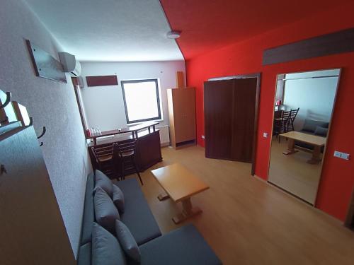 sala de estar con paredes rojas, sofá y mesa en Motel Gas-Petrol Samac, en Bosanski Šamac