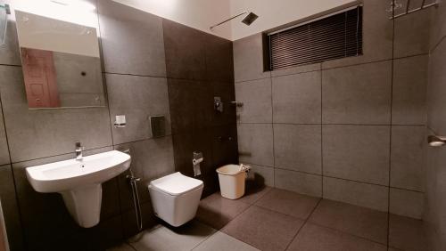 a bathroom with a sink and a toilet at Adrak Mountain Mist Forest Resort in Pulpally