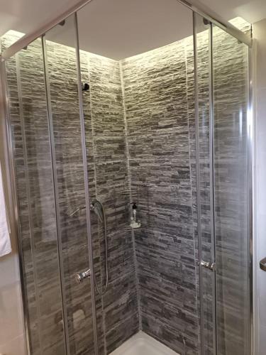 a bathroom with a shower with a glass door at La cabaña de Seña in Laredo