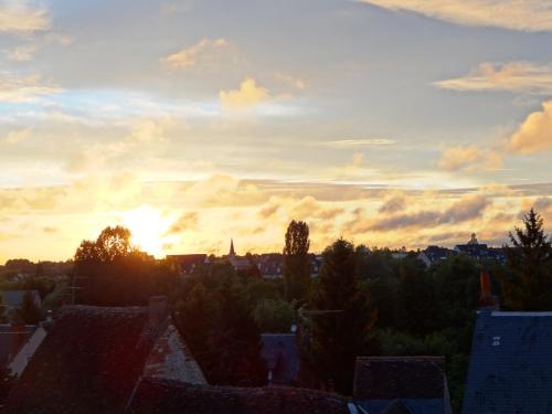 a sunset view of a city with roofs at Le Fassardy in Châteauroux