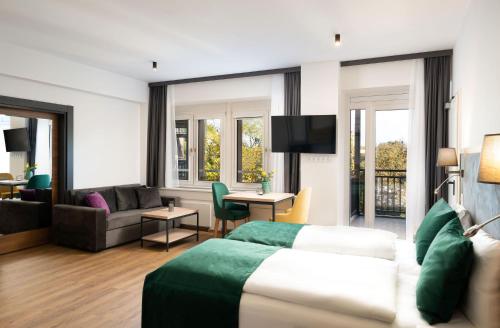 リュッセルスハイムにあるDIWOTEL l RÜSSELSHEIMのベッドとリビングルームが備わるホテルルームです。