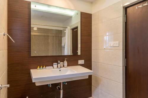a bathroom with a white sink and a mirror at SaffronStays Gardens On The Lake, Bhimtal - pet-friendly garden villa by the lake in Bhīm Tāl