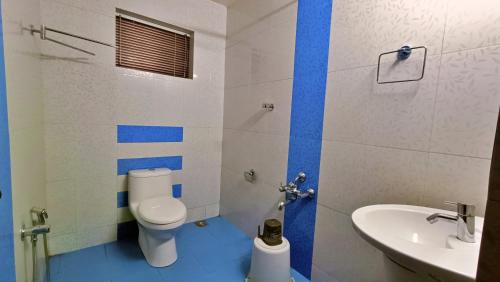 a bathroom with a toilet and a sink at Adrak Mountain Mist Forest Resort in Pulpally