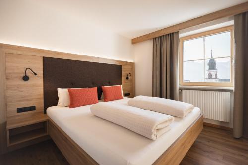 a bedroom with a large white bed with orange pillows at Apartement Almhof Fiss in Fiss