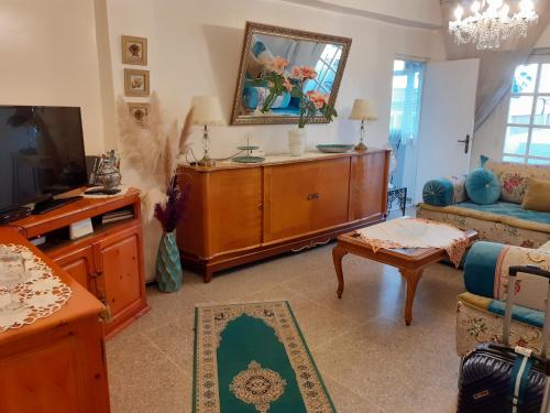 een woonkamer met een bank en een tv bij Appartment Avenue Hassan II in Agadir
