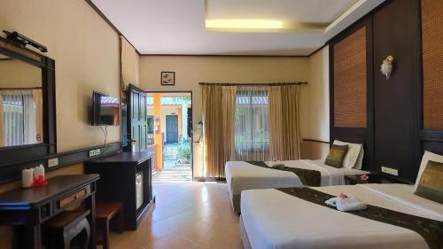 a hotel room with two beds and a television at Penny's Resort in Ko Chang