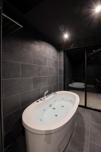 a bath tub in a bathroom with two lights at Hakuba Aurora Chalet by Jade Group in Hakuba