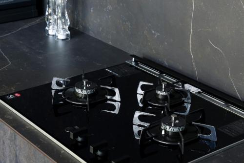 a black stove top with two burners on a counter at Hakuba Aurora Chalet by Jade Group in Hakuba