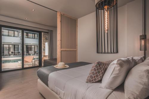 een slaapkamer met een bed, een bank en een raam bij Cavo di Suites in Kalamaki
