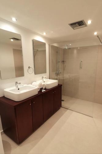 a bathroom with two sinks and a shower at Helion Apartments in Gouvia