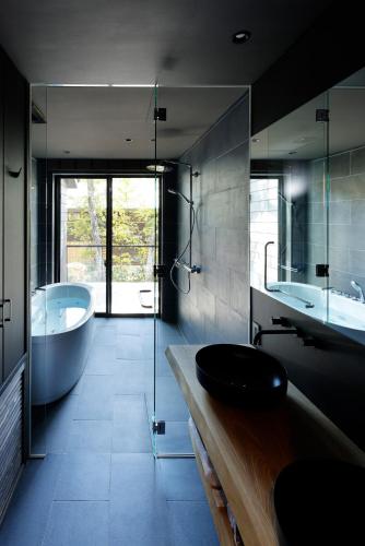 a bathroom with a tub and a sink and a bath tub at Hakuba Aurora Chalet by Jade Group in Hakuba