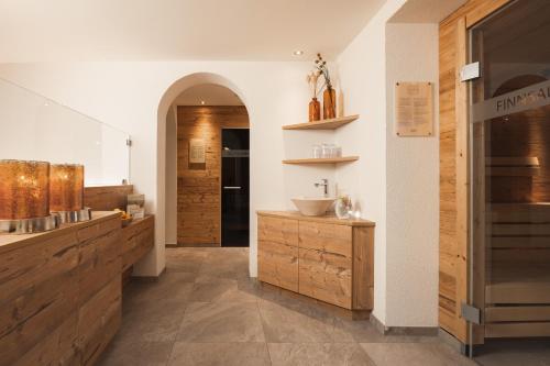 a kitchen with wooden cabinets and a sink in a room at Almhof Fiss in Fiss