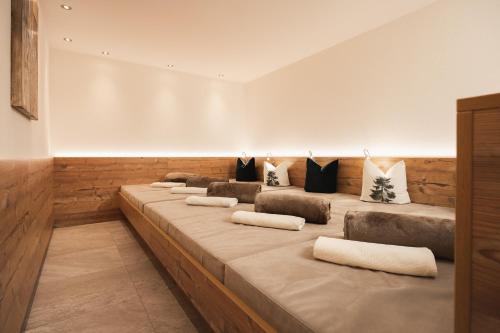 a room with a row of beds with pillows at Apartement Almhof Fiss in Fiss