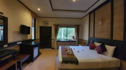 a bedroom with a large bed and a television at Penny's Resort in Ko Chang