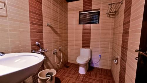 a bathroom with a white toilet and a sink at Adrak Mountain Mist Forest Resort in Pulpally