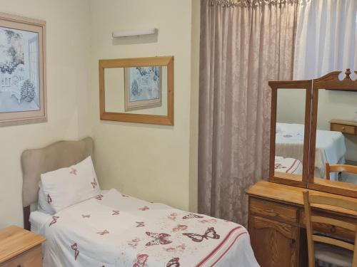 Dormitorio pequeño con cama y espejo en Alexandra Bed & Breakfast en Pelham