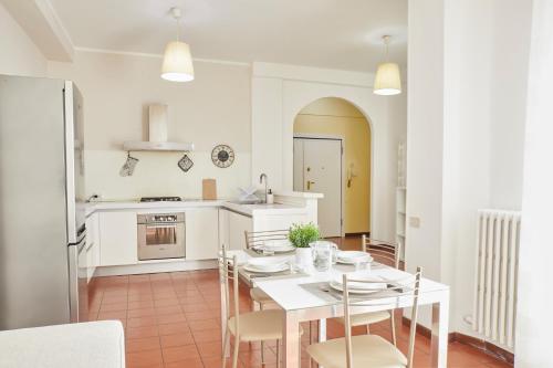 cocina blanca con mesa blanca y sillas en Piazza Centrale - Spazio, Comfort e WiFi, en Civitanova Marche