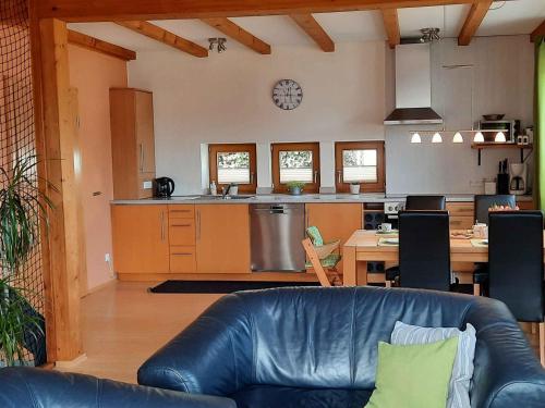 een woonkamer met een leren bank en een keuken bij Ferienwohnung Quinkert in Eslohe