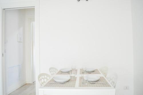 a white dining room with a white table and chairs at Homiday - Residenza Caravelle in Pineto