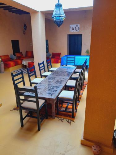 a dining room with a long table and chairs at Gite d'étape nomade in Tajda
