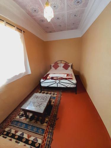 a small room with a bed and a table in it at Gite d'étape nomade in Tajda