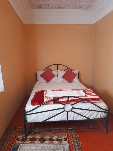 a bedroom with a bed with red pillows on it at Gite d'étape nomade in Tajda