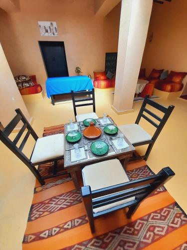 a dining table and chairs in a living room at Gite d'étape nomade in Tajda