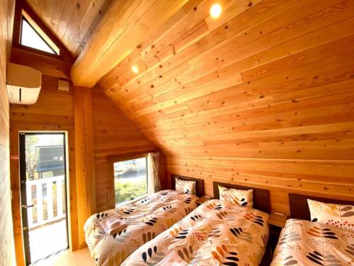 two beds in a room with wooden walls at Polar Haus Canadian NishiKaruisawa1 - Vacation STAY 07669v in Oiwake