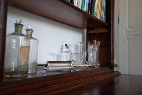 a wooden shelf with glasses and a bottle on it at Au Chantecler in Malzy