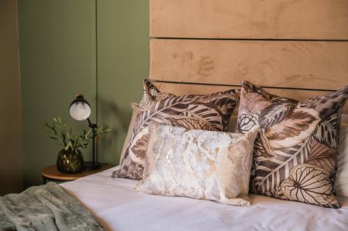 Una cama con un montón de almohadas. en The Olive Tree, en Ceres