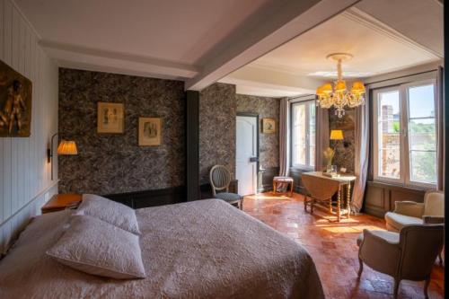 a bedroom with a large bed and a living room at Au Chantecler in Malzy
