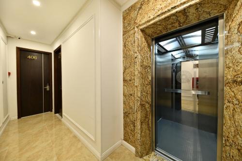 a hallway with a glass door and a stone wall at Kingdom Hotel Hanoi in Hanoi
