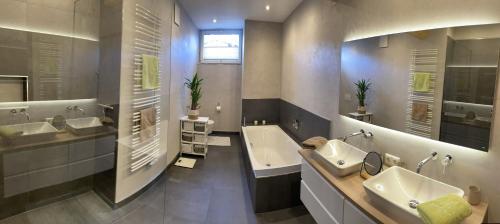 a large bathroom with two sinks and a bath tub at Apartments Golfweg in Kitzbühel