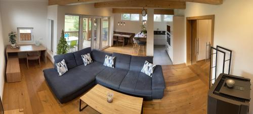 a living room with a blue couch and a kitchen at Apartments Golfweg in Kitzbühel